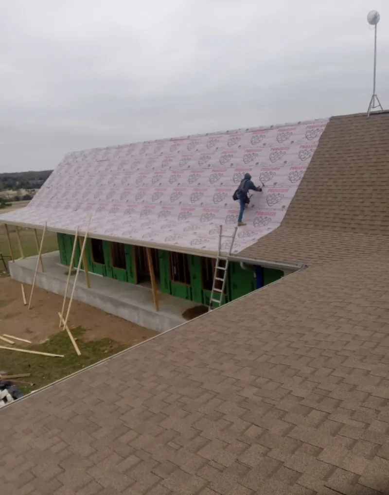 Worker preparing underlayment for a metal roof installation in Waihee-Waiehu
